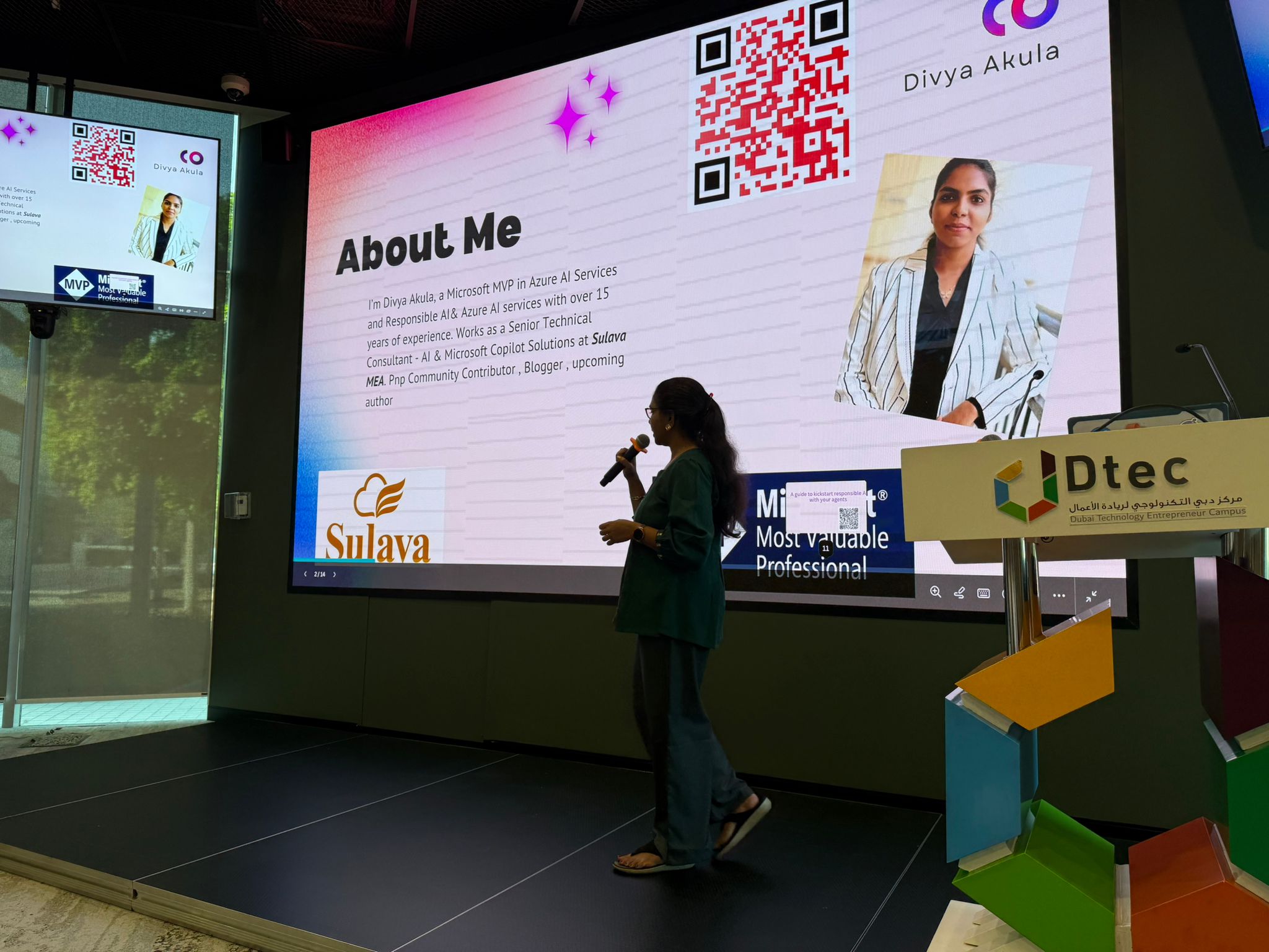 Divya presenting with a microphone at Dubai Technology Entrepreneur Campus